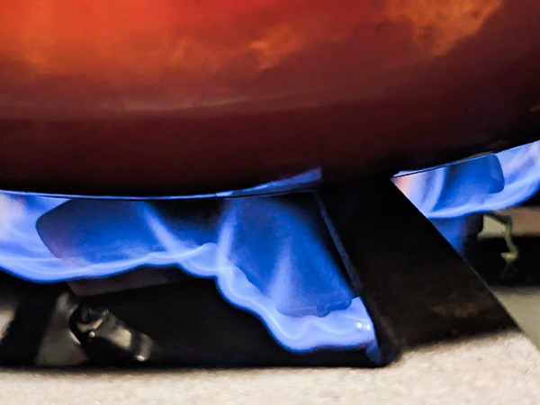 gas stove flame under red pot